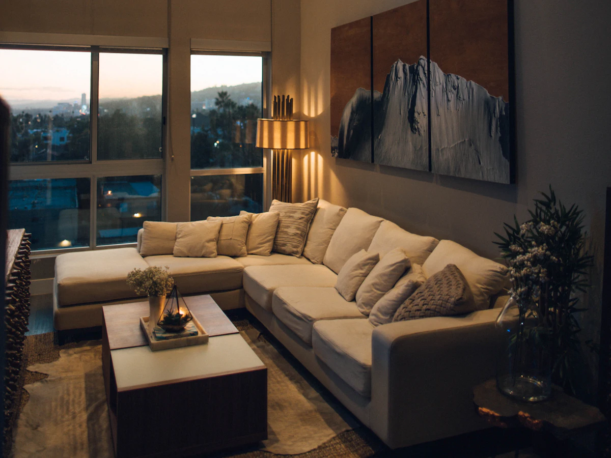 Living con sillón en L y ventanal con vista a la ciudad